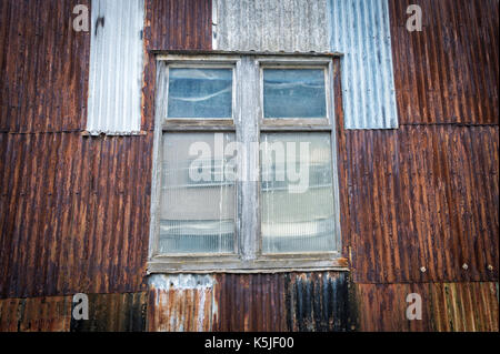 Rusty ferro corrugato edificio, magazzino con finestra. Foto Stock