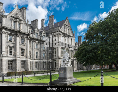 Dublino, Irlanda - 7 agosto 2017: laureati memorial building con george statua di salmone al Trinity College. edificio grigio sotto il cielo blu con il bianco cl Foto Stock