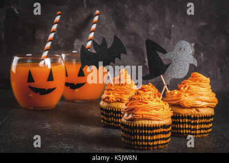 Semplice idea di funny kid's trattare per Halloween: torte di zucca con crema, con decorazioni in forma di simboli per le vacanze - ghost, strega, bat. su un bl Foto Stock