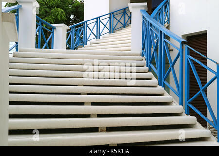 All'esterno bianco scala con ringhiera blu conduce al piano superiore Foto Stock