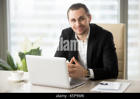 Ritratto di bello sorridente imprenditore della tuta in ufficio. Foto Stock