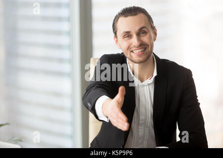 Gentile imprenditore sorridente offrendo la mano per il messaggio di saluto o d'accordo Foto Stock