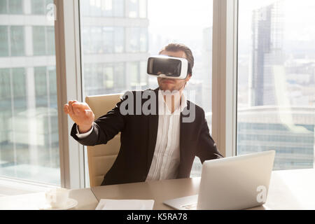 Lavoratore di ufficio in vr auricolare rivolto nell'aria. Foto Stock