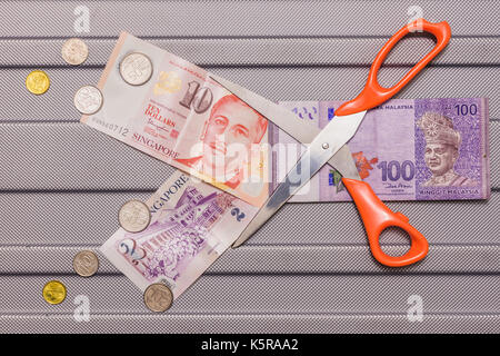 Dollaro di Singapore e le monete sulla parte superiore di ringgit malese valuta su pattern di sfondo, concetto scambi di valuta il valore monetario taglio basso, malese Foto Stock