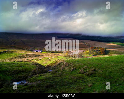 Una vista di Widdale in Wensleydale, North Yorkshire, come un raggio di sole si rompe in un cielo tempestoso Foto Stock