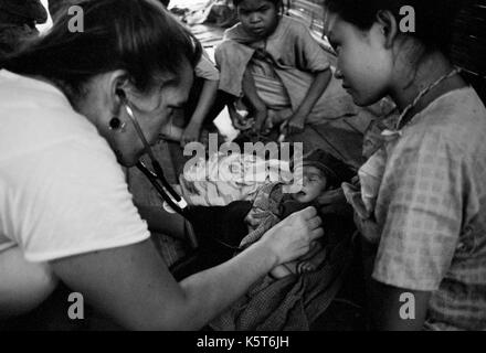 Dott.ssa Maria Washburne esamina un rifugiati birmani infantile a Shok La campo profughi nel nord-ovest della Thailandia; un campo solo per quelli con sintomi di colera. Settembre, 1996. Foto Stock