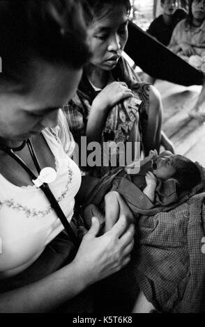 Dott.ssa Maria Washburne esamina un rifugiati birmani infantile a Shok La campo profughi nel nord-ovest della Thailandia; un campo solo per quelli con sintomi di colera. Settembre, 1996. Foto Stock