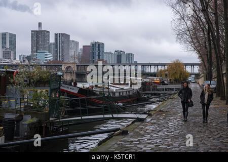 Due giovani donne a piedi lungo la Senna a Parigi, Francia, con il Bir Hakeim bridge in background su un giorno d'inverno. Foto Stock
