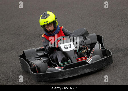 I ragazzi imparano a guidare i kart su una pista durante una junior karting corso a Thruxton racing circuito di Thruxton Hampshire, Inghilterra Foto Stock