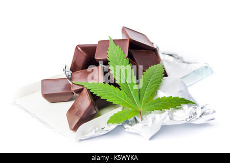 Foglia di marijuana con cubetti di cioccolato su sfondo bianco Foto Stock