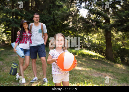 Giovane e bella famiglia con figlia camping nella foresta. Foto Stock