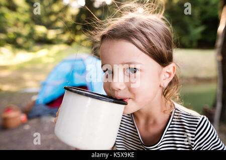 Carino bambina camping all'aperto, acqua potabile. Foto Stock