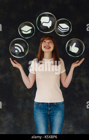 Studio shot di una giovane donna tenendo le sue braccia e guardando verso l'alto mentre sorridente. Non ci sono bolle di vettore con life-le relative icone nel loro arou flottante Foto Stock