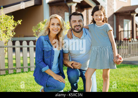 La famiglia felice in posa vicino la loro nuova casa Foto Stock
