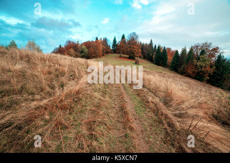 Montagne di colore arancione e il sole nel cielo blu Foto Stock