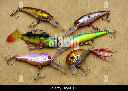 Esche per la pesca su tela sfondo. wobblers di diversi colori. Foto Stock