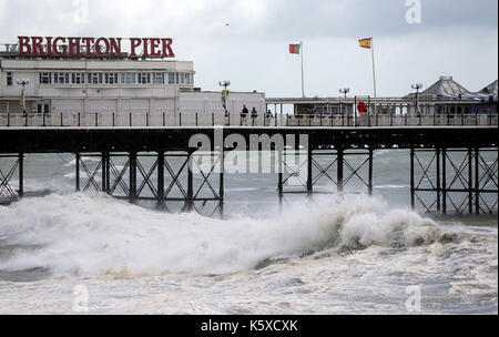 Alta venti frusta fino il mare in tempesta intorno al molo di Brighton, come le inondazioni ha colpito autostrade, strade e ferrovie nel nord dell'Inghilterra con avvisi di più brutto tempo sulla strada. Foto Stock