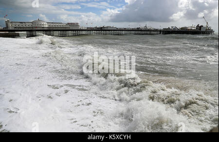Alta venti frusta fino il mare in tempesta intorno al molo di Brighton, come le inondazioni ha colpito autostrade, strade e ferrovie nel nord dell'Inghilterra con avvisi di più brutto tempo sulla strada. Foto Stock