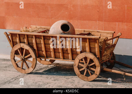 Carrello in legno con brocca di argilla all'interno. Foto Stock