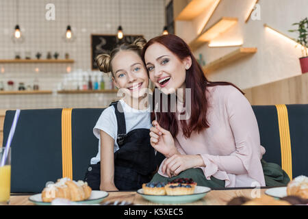 Madre e figlia in cafe con dessert Foto Stock