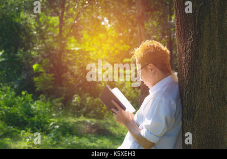 La donna la lettura di un libro gode del resto. donna mano che tiene un libro per leggere. concetti di riposo e comfort. Foto Stock