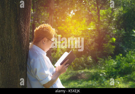 La donna la lettura di un libro gode del resto. donna mano che tiene un libro per leggere. concetti di riposo e comfort. Foto Stock