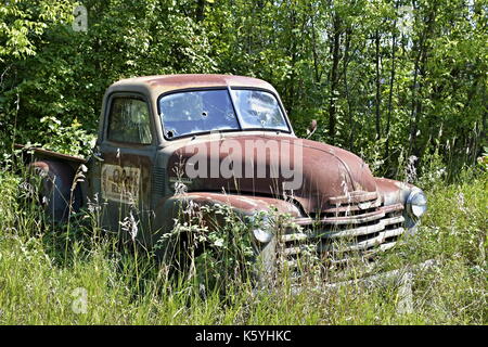 Un vecchio pick-up Chevrolet abbandonato seduto in un campo Foto Stock