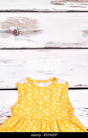 Baby-ragazza abito modellato. bambini bel giallo sundress con un modello di piccoli fiori bianchi, copia dello spazio. Foto Stock