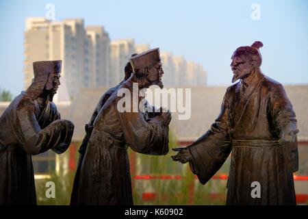 Cultura dongzi park, dezhou, Cina. statua del filosofo confuciano dong zhongshu parlando con alcuni inviati sulla piattaforma di lettura Foto Stock