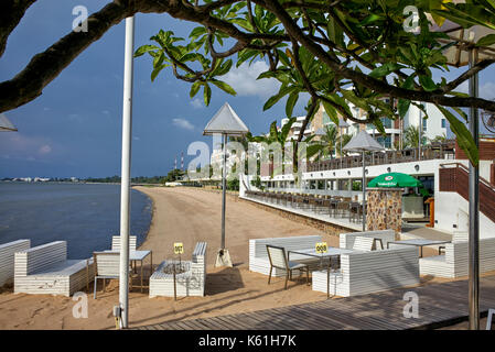 Area ristorante del resort sulla spiaggia Thailandese con tavoli e sedie che si affacciano sull'oceano. Pattaya, Thailandia, Sud-Est Asiatico Foto Stock