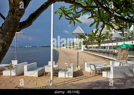 Area ristorante del resort sulla spiaggia Thailandese con tavoli e sedie che si affacciano sull'oceano. Pattaya, Thailandia, Sud-Est Asiatico Foto Stock