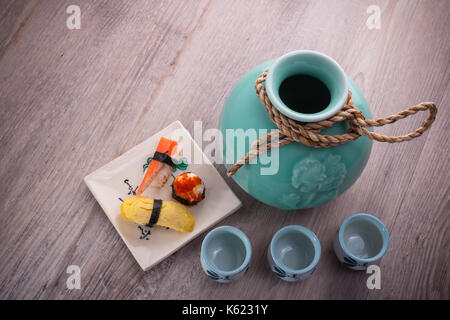 Giappone sake bottiglia impostata su uno sfondo di legno Foto Stock