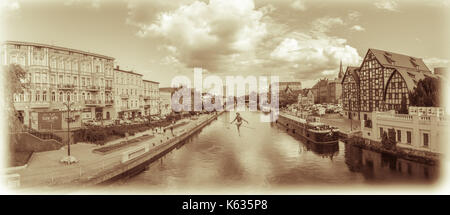 Bydgoszcz, Polonia - Agosto 2017 : seppia vintage panorama di Bydgoszcz con il funambolo scultura oltre il fiume Brda Foto Stock