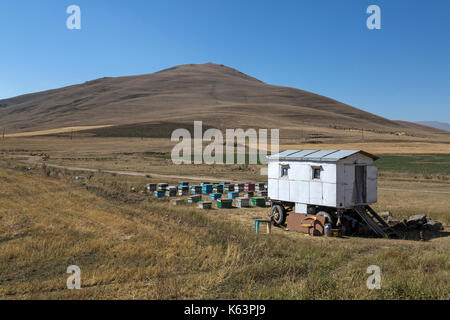 Piccola casa mobile su ruote, con alveari dietro, appena fuori da una strada in Armenia. Il popolo nella casa vendere il miele dal ciglio della strada. Foto Stock