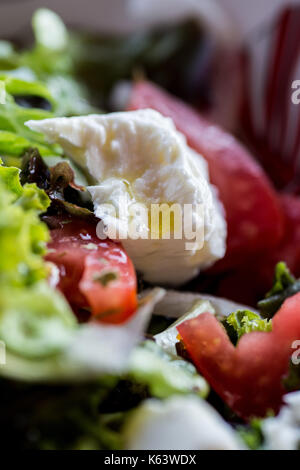 Insalata greca con formaggio feta, olio d'oliva, pomodori, lattuga, cipolla e origano. verdure fresche. Foto Stock