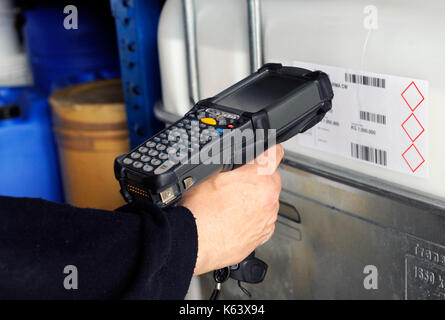 Mano umana tenendo uno scanner di codici a barre per i codici di scansione Foto Stock