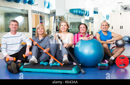 Felice anziani attivi gli uomini e le donne con le sfere di fitness e manubri in una palestra Foto Stock