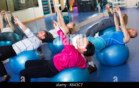 Gruppo di felice adulti facendo aerobica con le palline in un club di sport Foto Stock