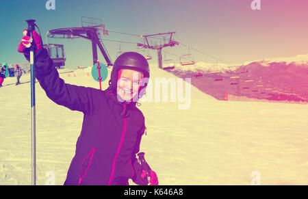Primo piano su sorridendo felice donna positiva indossare equipaggiamento da sci e sci di fondo in neve montagne Foto Stock