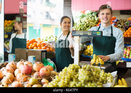 Sorridente roba grembiuli in vendita banane dolce al marketplace Foto Stock