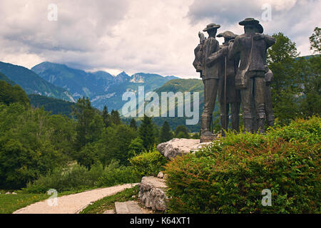 Ribcev Laz, Slovenia - 4 luglio 2017: il parco cittadino vicino al lago di Bohinj con il monumento a quattro uomini coraggiosi che scalato la montagna più alta del Tricorno in Foto Stock