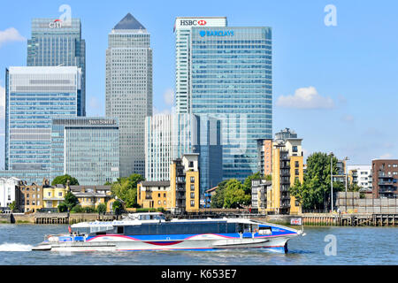 Lo skyline di Londra paesaggio urbano di Canary Wharf Barclays Bank & HSBC e moderno grattacielo edifici banca Thames Clipper ad alta velocità bus fiume passando di servizio Foto Stock