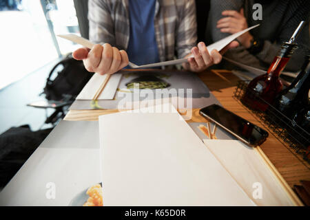 Birmingham, Regno Unito - 6 November 2016: uomo seduto a tavola Guardando Wagamama Ristorante Menu Foto Stock