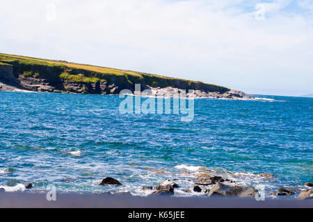 Paesaggio di colpo la linea costiera a Cromwell punto,Valentia Island, Ring of Kerry, Irlanda su un luminoso giorno contro un cielo blu con nuvole cirrus Foto Stock