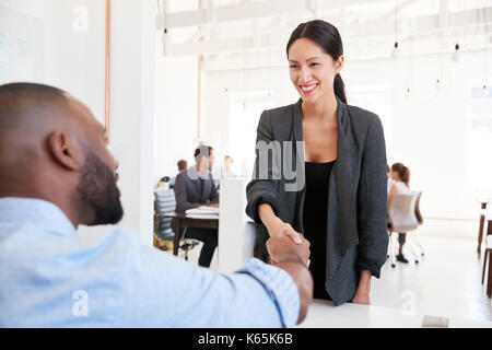 La donna saluto un imprenditore di colore nero presso un ufficio sale riunioni Foto Stock