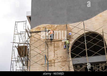 Lavoratori sui ponteggi del villaggio di estensione del mercato edificio in costruzione, Kenya Foto Stock