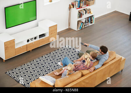 Elevato angolo di visione della famiglia seduti sul divano in salotto guardando la TV Foto Stock