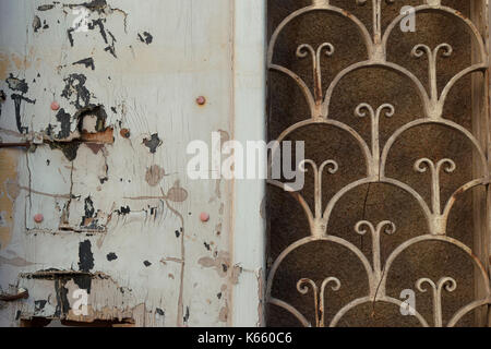 Weathered casa abbandonata la vecchia porta con metallo arrugginito pattern e rotture di scaglie di legno texture di sfondo. Foto Stock