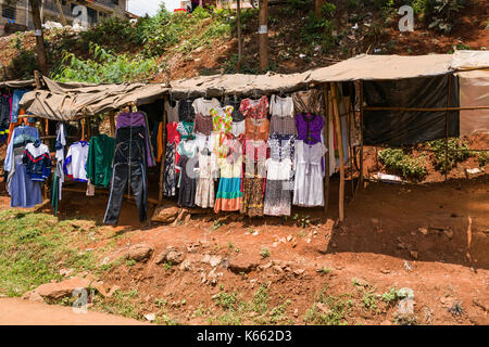 Le bancarelle del mercato di vendita sul ciglio della strada e la visualizzazione di abbigliamento, Kenya Foto Stock