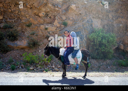 Due ragazzi su un asino in Marocco, Africa del nord Foto Stock